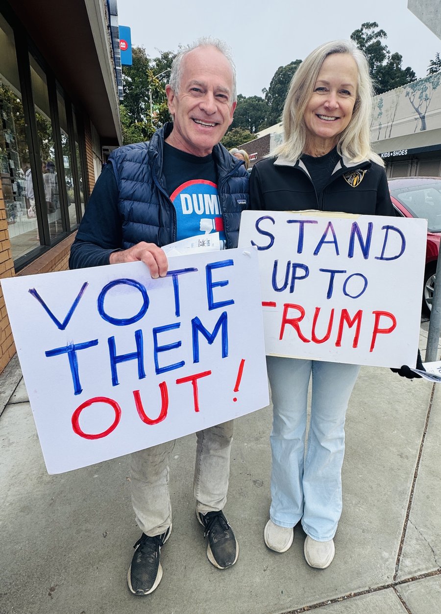 RAEB volunteers holding Vote Them Out and Stand Up to Trump signs